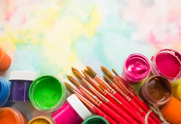 Paints, brushes and palette on the colorful background. — Stock Photo, Image