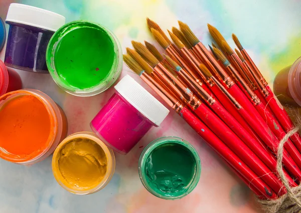 Paints, brushes and palette on the colorful background. — Stock Photo, Image