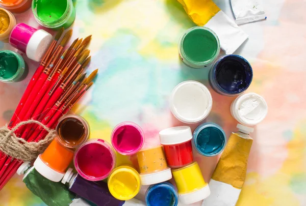 Tintas, pincéis e paleta sobre o fundo colorido . — Fotografia de Stock