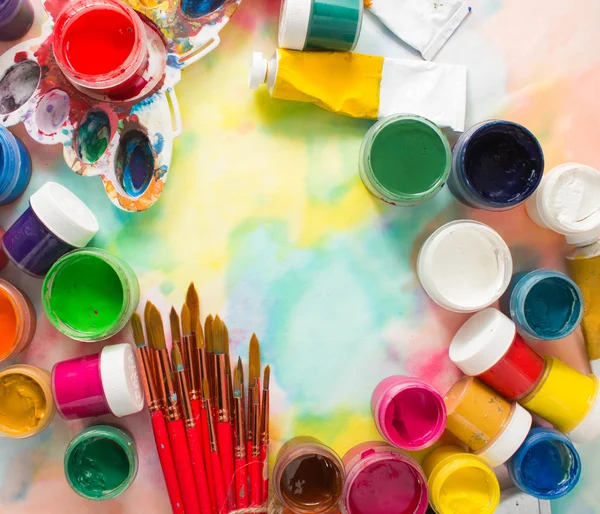 Färger, penslar och palett på färgstarka bakgrund. — Stockfoto