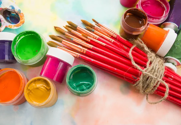 Tintas, pincéis e paleta sobre o fundo colorido . — Fotografia de Stock