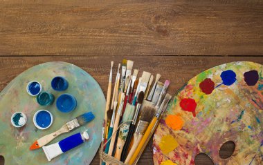 Fırçalar ve ahşap zemin üzerine palet. 