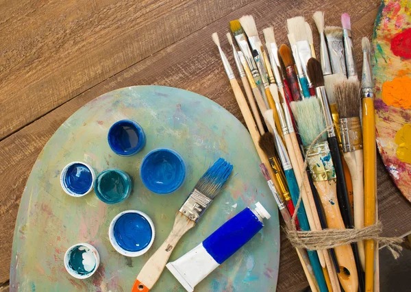 Fırçalar ve ahşap zemin üzerine palet. 