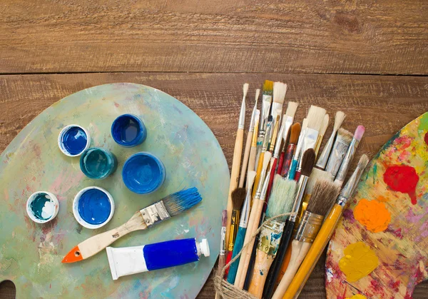 Paints, brushes and palette on the wood background. — Stock Photo, Image