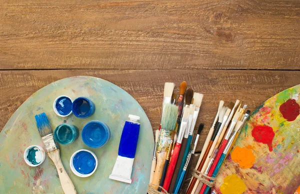 Pinturas, pinceles y paletas sobre el fondo de madera . —  Fotos de Stock