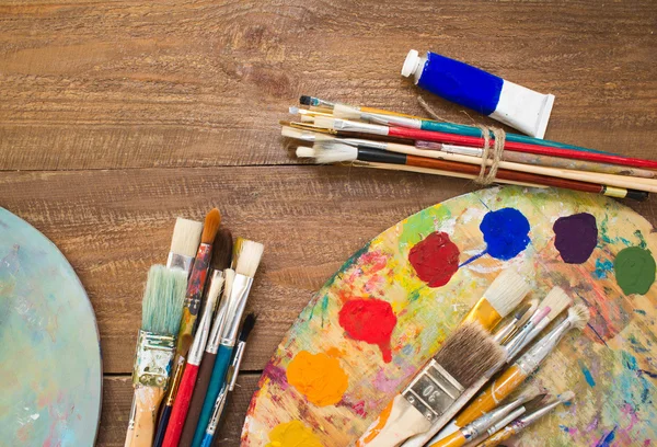 Paints, brushes and palette on the wood background. — Stock Photo, Image