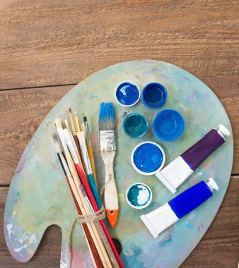 Fırçalar ve ahşap zemin üzerine palet. 