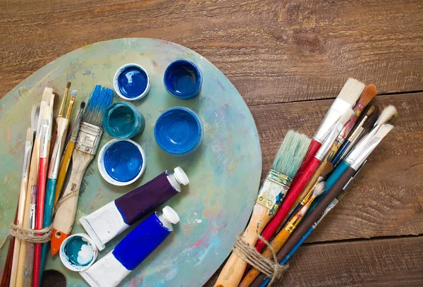 Fırçalar ve ahşap zemin üzerine palet. 