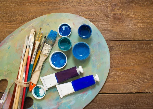Fırçalar ve ahşap zemin üzerine palet. 