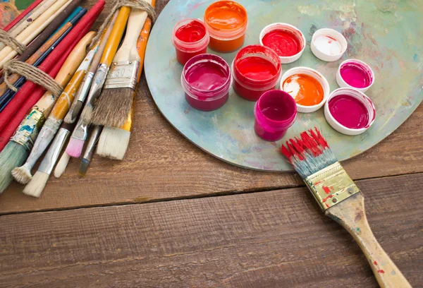 Pinturas, pinceles y paletas sobre el fondo de madera . — Foto de Stock