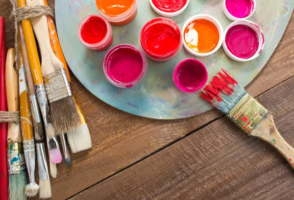 Fırçalar ve ahşap zemin üzerine palet. 
