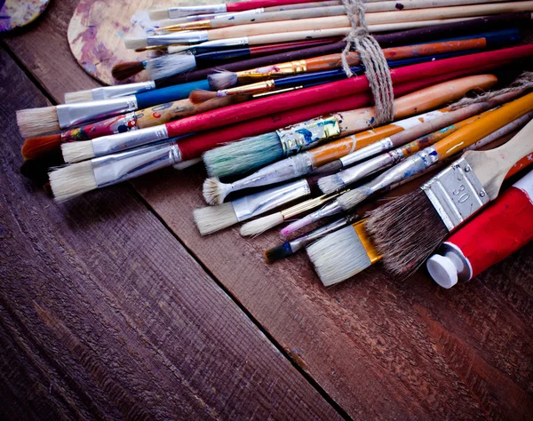 Fırçalar ve ahşap zemin üzerine palet. 
