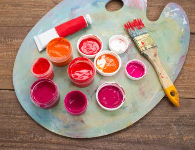 Renkli boyalar, fırçalar, palet ahşap arka plan üzerinde. 