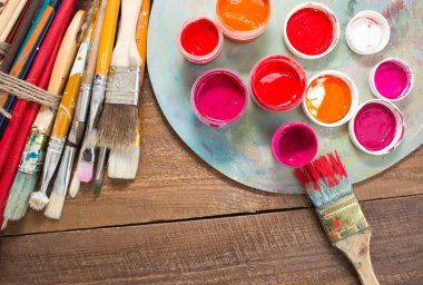 Renkli boyalar, fırçalar, palet ahşap arka plan üzerinde. 