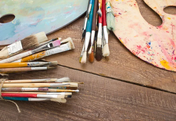 Kleurrijk verf, penselen, palet op de houten achtergrond. — Stockfoto
