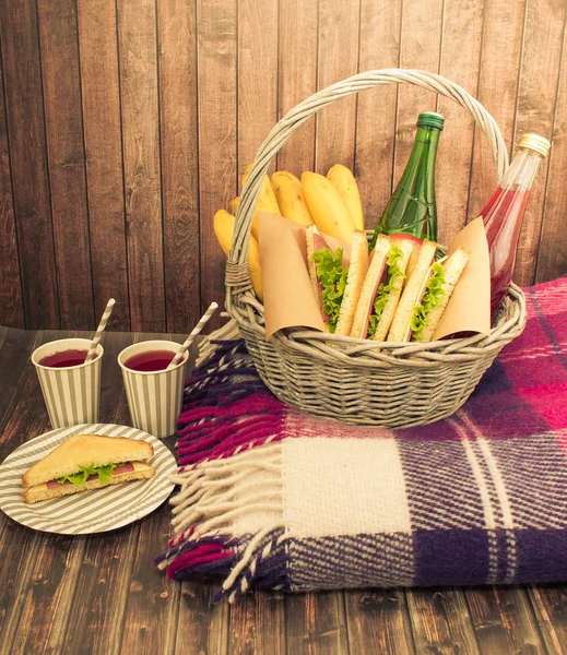 Comida e coisas para um piquenique no fundo de madeira — Fotografia de Stock