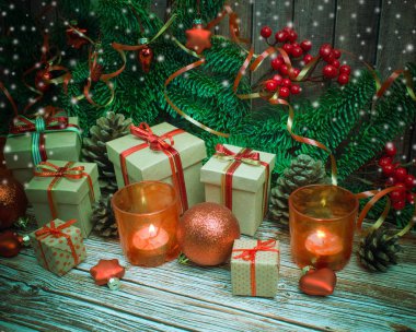 Noel ve yeni yıl arka plan: cam oyuncaklar, mumlar ve hediyeler ahşap arka plan üzerinde renkli