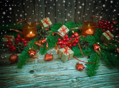 Noel ve yeni yıl arka plan: cam oyuncaklar, mumlar ve hediyeler ahşap arka plan üzerinde renkli