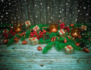 Noel ve yeni yıl arka plan: cam oyuncaklar, mumlar ve hediyeler ahşap arka plan üzerinde renkli