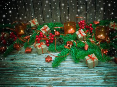 Noel ve yeni yıl arka plan: cam oyuncaklar, mumlar ve hediyeler ahşap arka plan üzerinde renkli