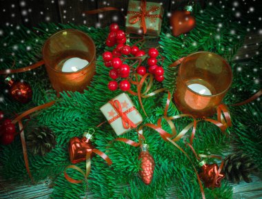 Noel ve yeni yıl arka plan: cam oyuncaklar, mumlar ve hediyeler ahşap arka plan üzerinde renkli