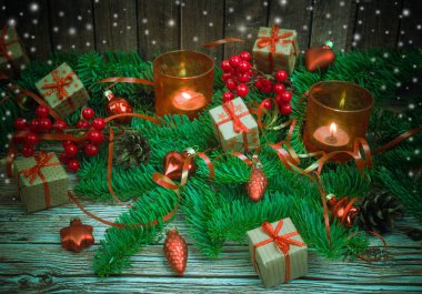 Noel ve yeni yıl arka plan: cam oyuncaklar, mumlar ve hediyeler ahşap arka plan üzerinde renkli