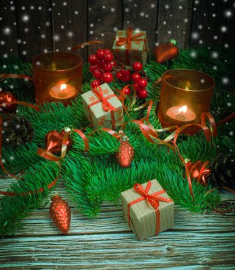 Noel ve yeni yıl arka plan: cam oyuncaklar, mumlar ve hediyeler ahşap arka plan üzerinde renkli