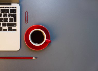 işyeri dizüstü bilgisayar ve kırmızı kahve fincanı. 