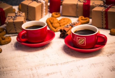 İki kırmızı kahve fincanı, bir kalp ve hediyeler şeklinde kurabiye 