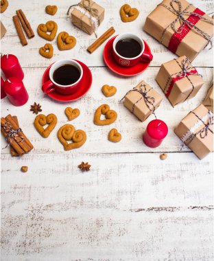 İki kırmızı kahve fincanı, bir kalp ve hediyeler şeklinde kurabiye 