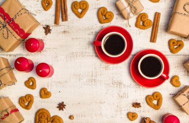 İki kırmızı kahve fincanı, bir kalp ve hediyeler şeklinde kurabiye 