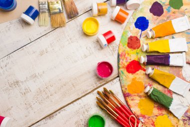 Fırçalar ve palet Beyaz ahşap zemin üzerinde.