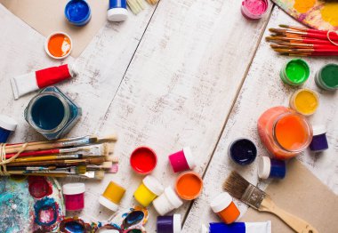 Fırçalar ve palet Beyaz ahşap zemin üzerinde.