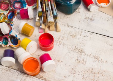 Fırçalar ve palet Beyaz ahşap zemin üzerinde.