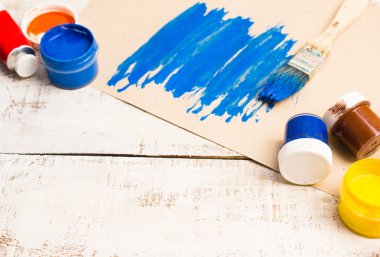 Fırçalar ve palet Beyaz ahşap zemin üzerinde.