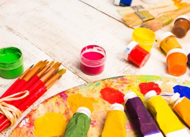 Fırçalar ve palet Beyaz ahşap zemin üzerinde.