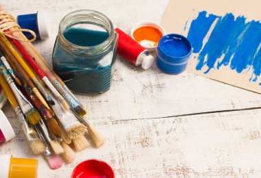 Fırçalar ve palet Beyaz ahşap zemin üzerinde.