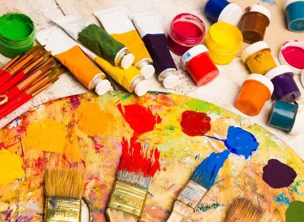 Paints, brushes and palette on the white wood background. — Stock Photo, Image