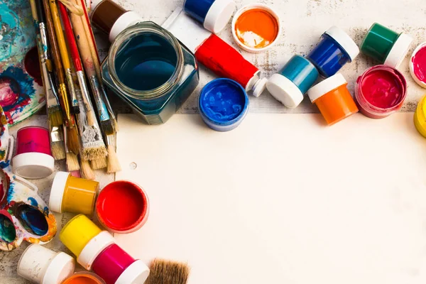 Paints, brushes and palette on the white wood background. — Stock Photo, Image