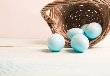 Sepeti ahşap zemin üzerine mavi Paskalya yumurtaları.