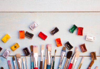 Boyalar, fırçalar ve palet ahşap arka plan üzerinde. Sanatçı işyeri. Okul için Banner. 