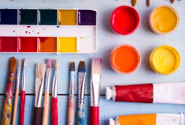 Boyalar, fırçalar ve palet ahşap arka plan üzerinde. Sanatçı işyeri. Okul için Banner. 