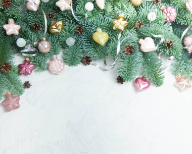 Noel veya Yeni Yıl arkaplanı: Beyaz arka planda köknar ağacı dalları, oyuncaklar ve koniler