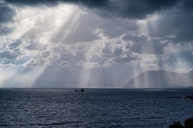 Güneşin ışınları Karadeniz kıyısındaki bulutların arasından geçiyor. Novorossiysk. Shirokaya Köyü Balka