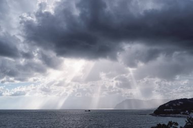 Güneşin ışınları Karadeniz kıyısındaki bulutların arasından geçiyor. Novorossiysk. Shirokaya Köyü Balka