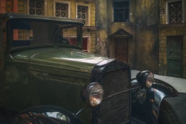 Eski bir askeri aracın kabininin bir kısmı harap olmuş bir binanın arka planında. Yakın plan..