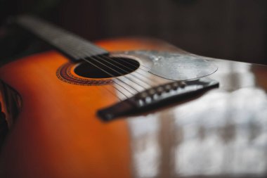 Koyu arkaplanda akustik gitar, doğal ışık seçici odak