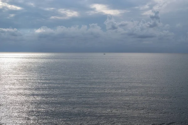 Uzakta, sakin bir denizde yalnız bir yelkenli, doğal akşam ışığı. Karadeniz