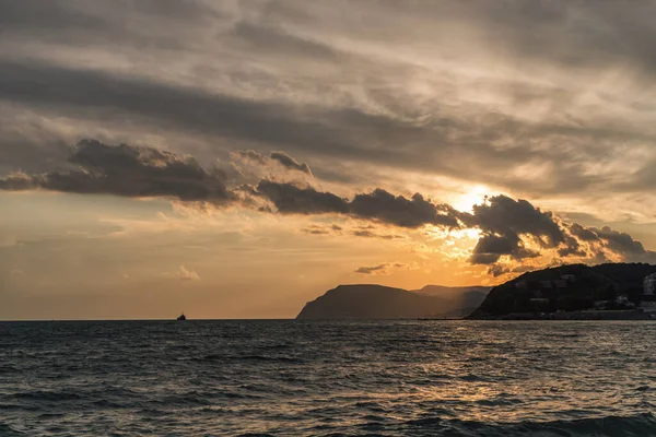 Karadeniz üzerinde bulutlu bir gökyüzünde gün batımı. Novorossiysk. Shirokaya Köyü Balka
