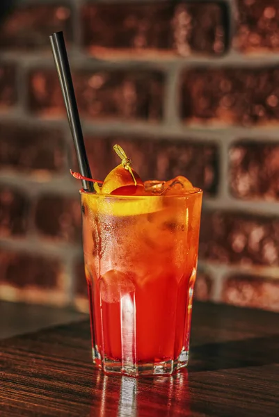 Masada kırmızı kokteyl. Koyu tuğla duvar arka planında.